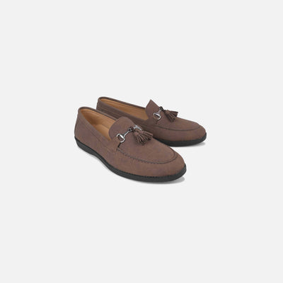 Pair of brown loafers with tassels on a light gray background