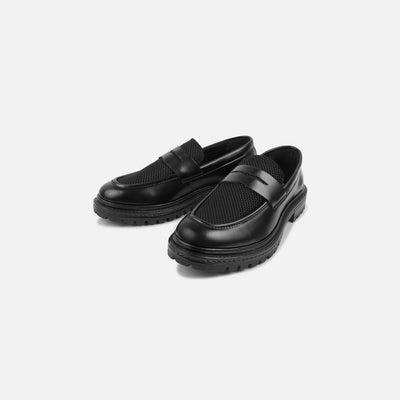 Black loafers on a light gray background