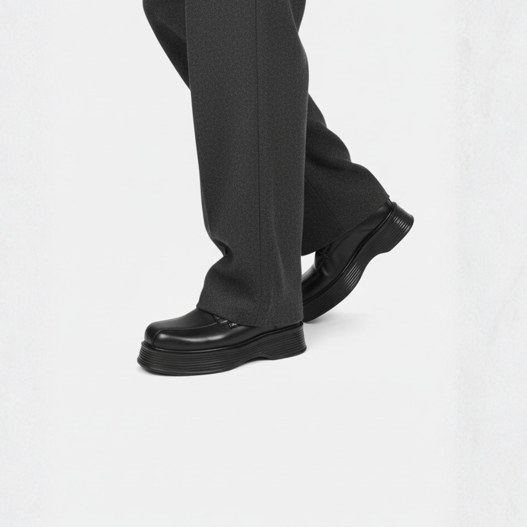 Black shoes worn with gray pants on a white background