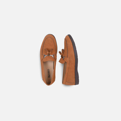Pair of brown loafers with tassels on a light gray background
