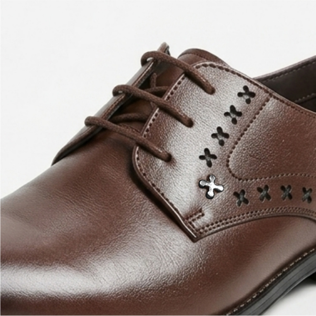 Brown leather dress shoe with decorative eyelets on a white background