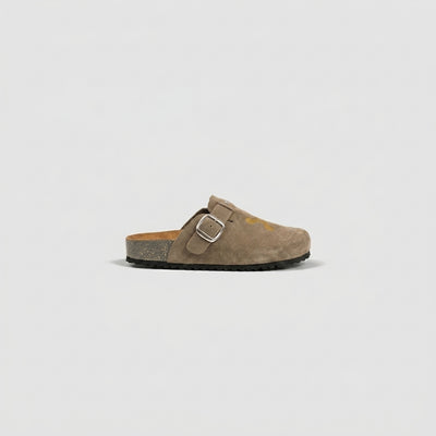 Brown sandal with a buckle on a light gray background