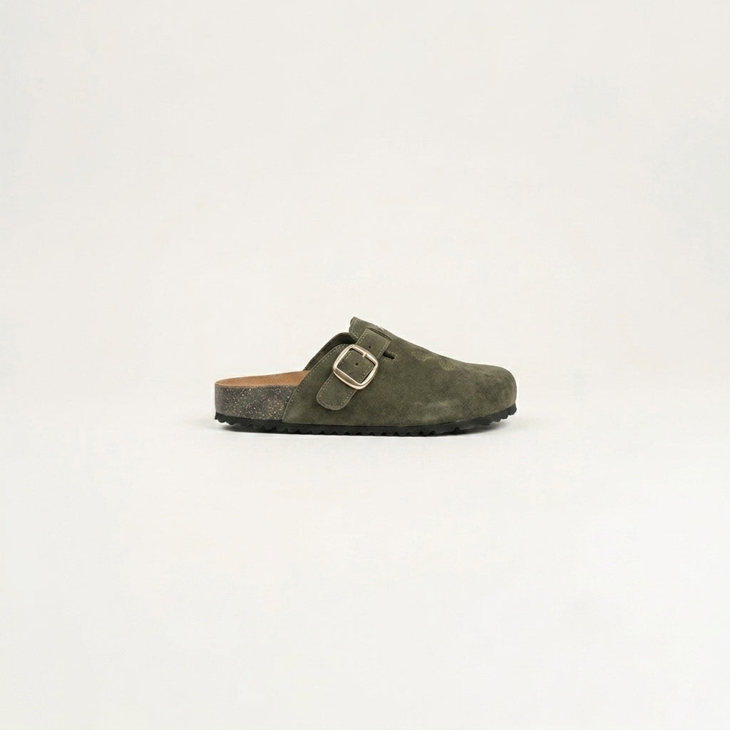Green suede clog shoe with a gold buckle on a light gray background