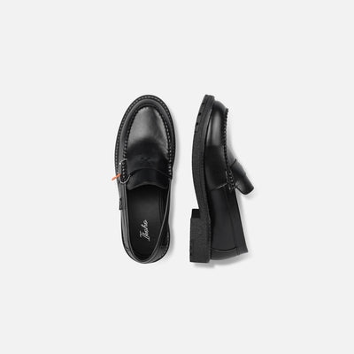Black loafers on a light gray background