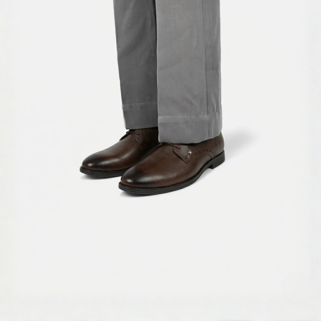 Brown leather shoes worn with gray pants on a white background