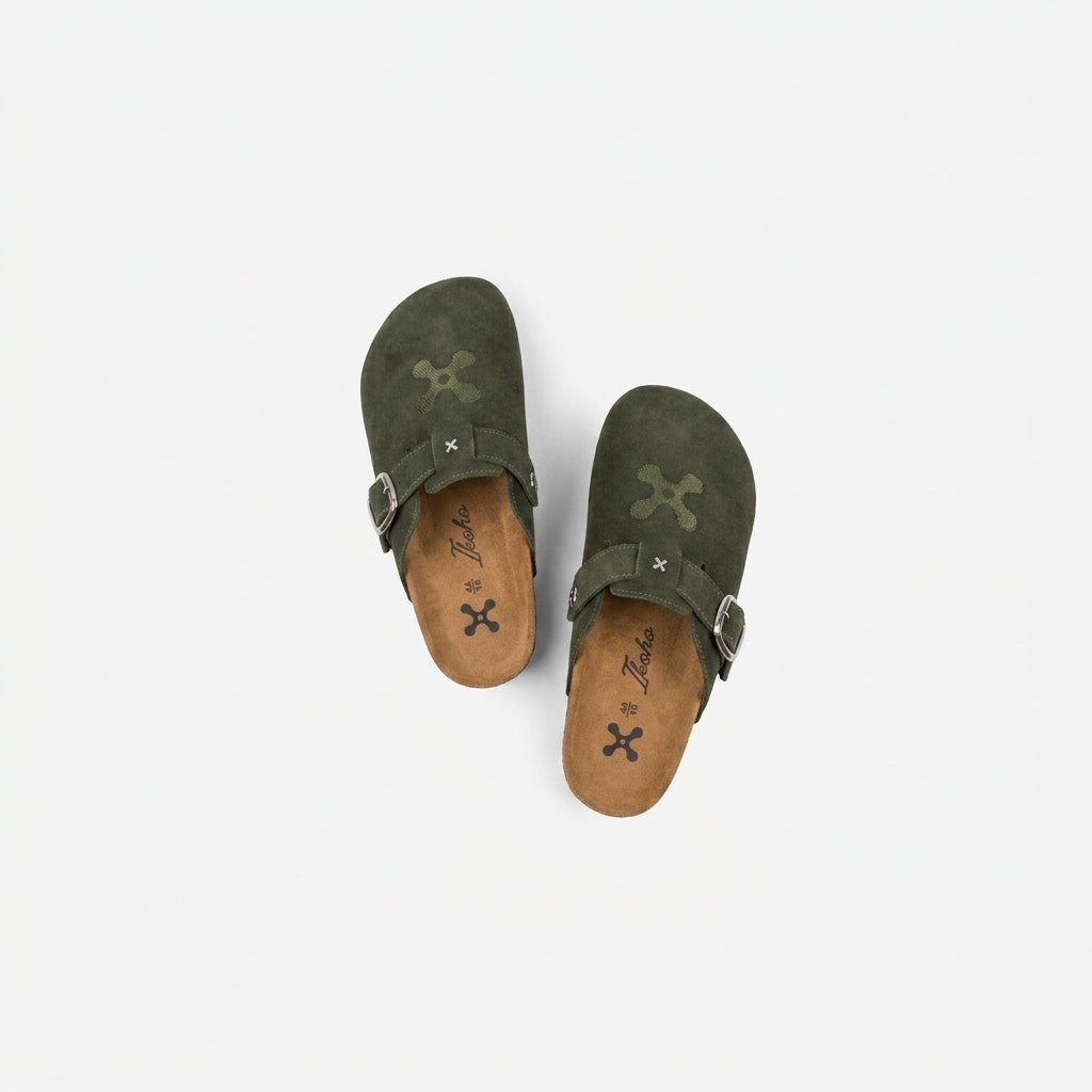 Pair of green sandals with brown soles on a white background