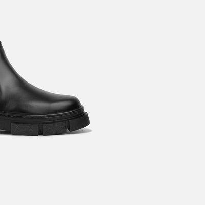 Black rain boot on a light gray background