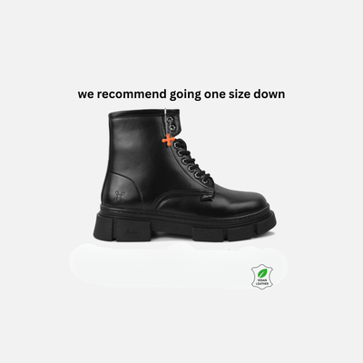 Black leather boot on a white background with text 'we recommend going one size down' and a green leaf logo.