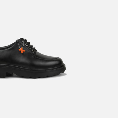 Black shoe with orange accents on a light gray background