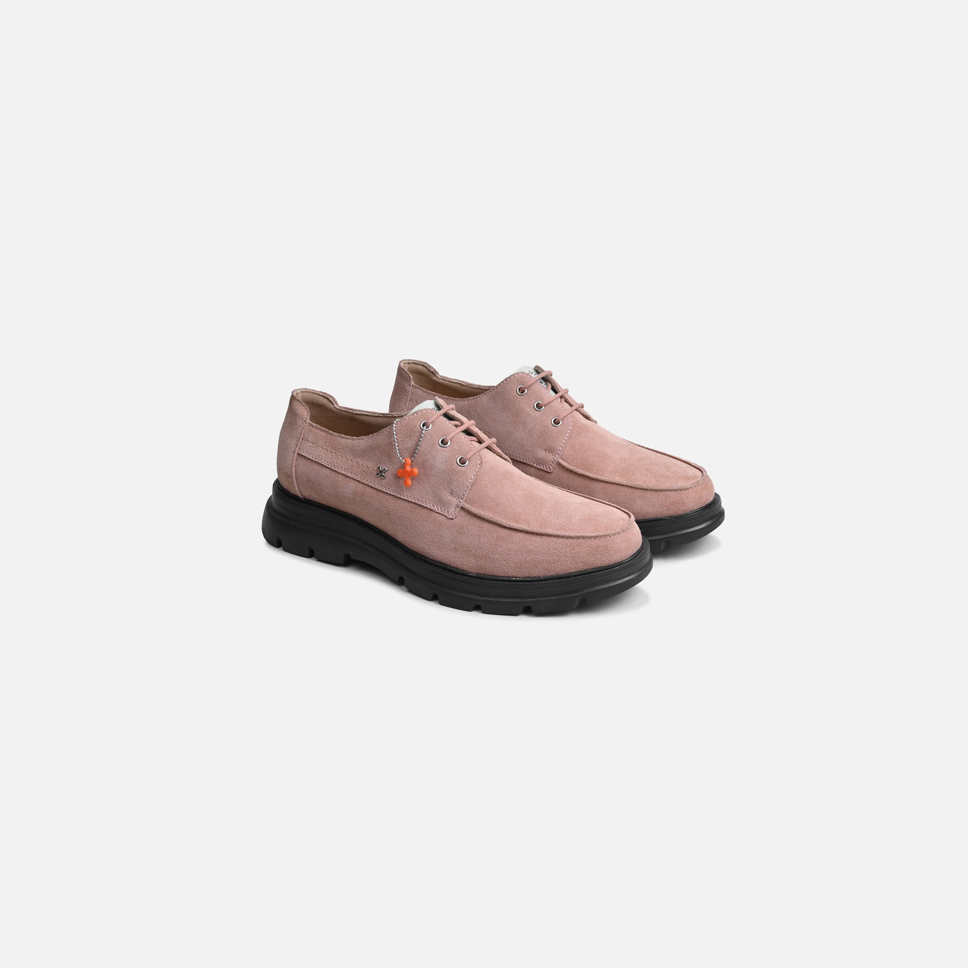 A pair of dusty pink suede lace-up shoes with black soles, displayed on a clean light gray background.