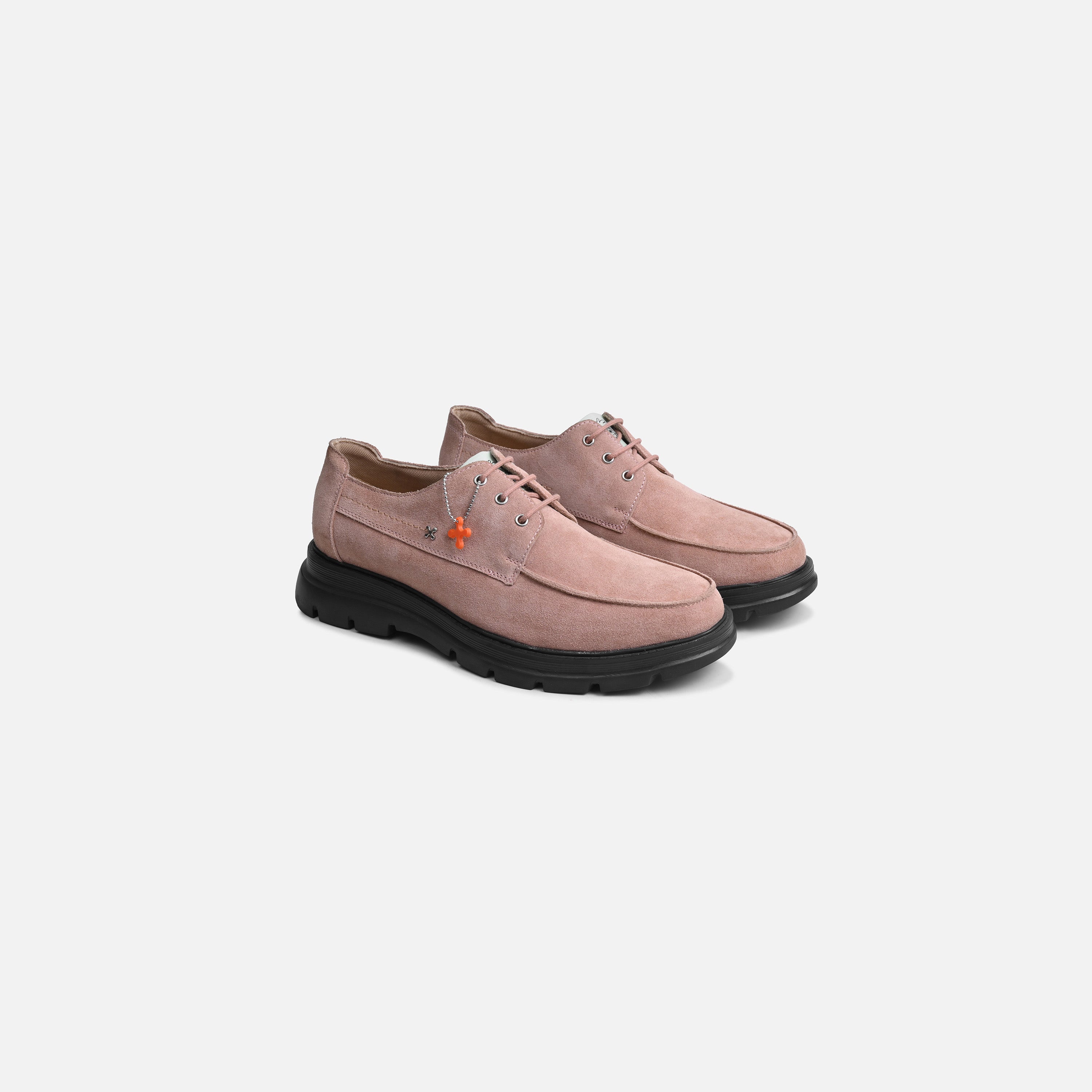 A pair of dusty pink suede lace-up shoes with black soles, displayed on a clean light gray background.