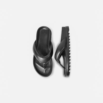 Black sandal with a strap on a light gray background