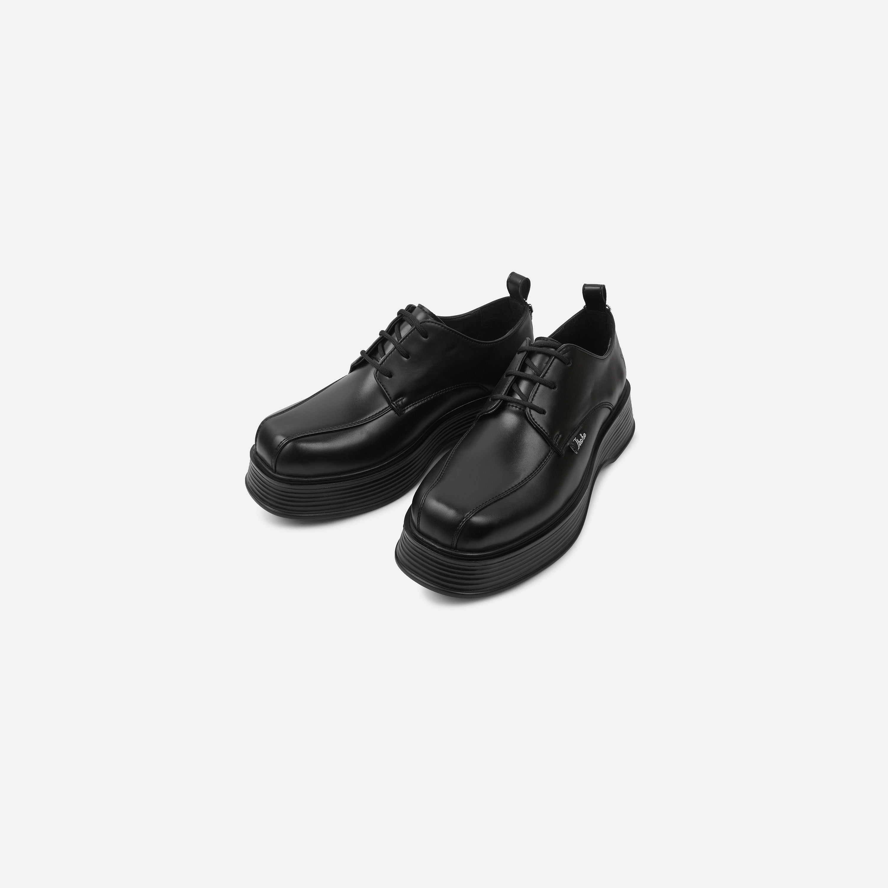 Pair of black leather shoes on a light gray background