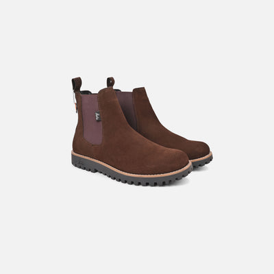 Pair of brown Chelsea boots on a light gray background