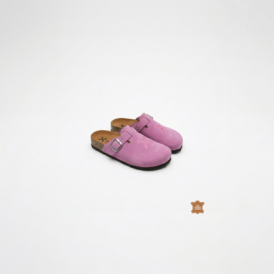 Pair of pink suede clogs on a white background