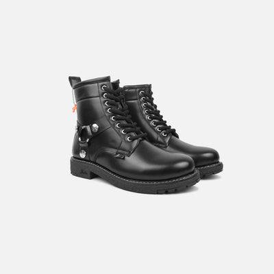 Pair of black leather boots with silver buckles on a light gray background
