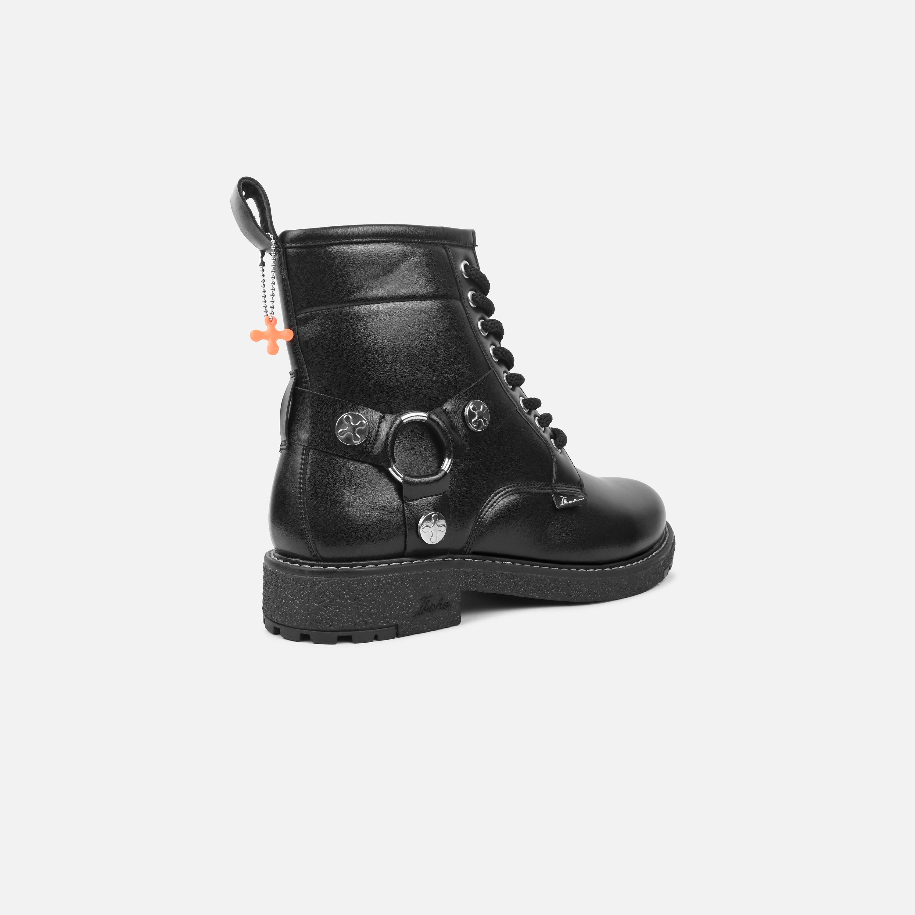 Black leather boot with decorative elements on a white background