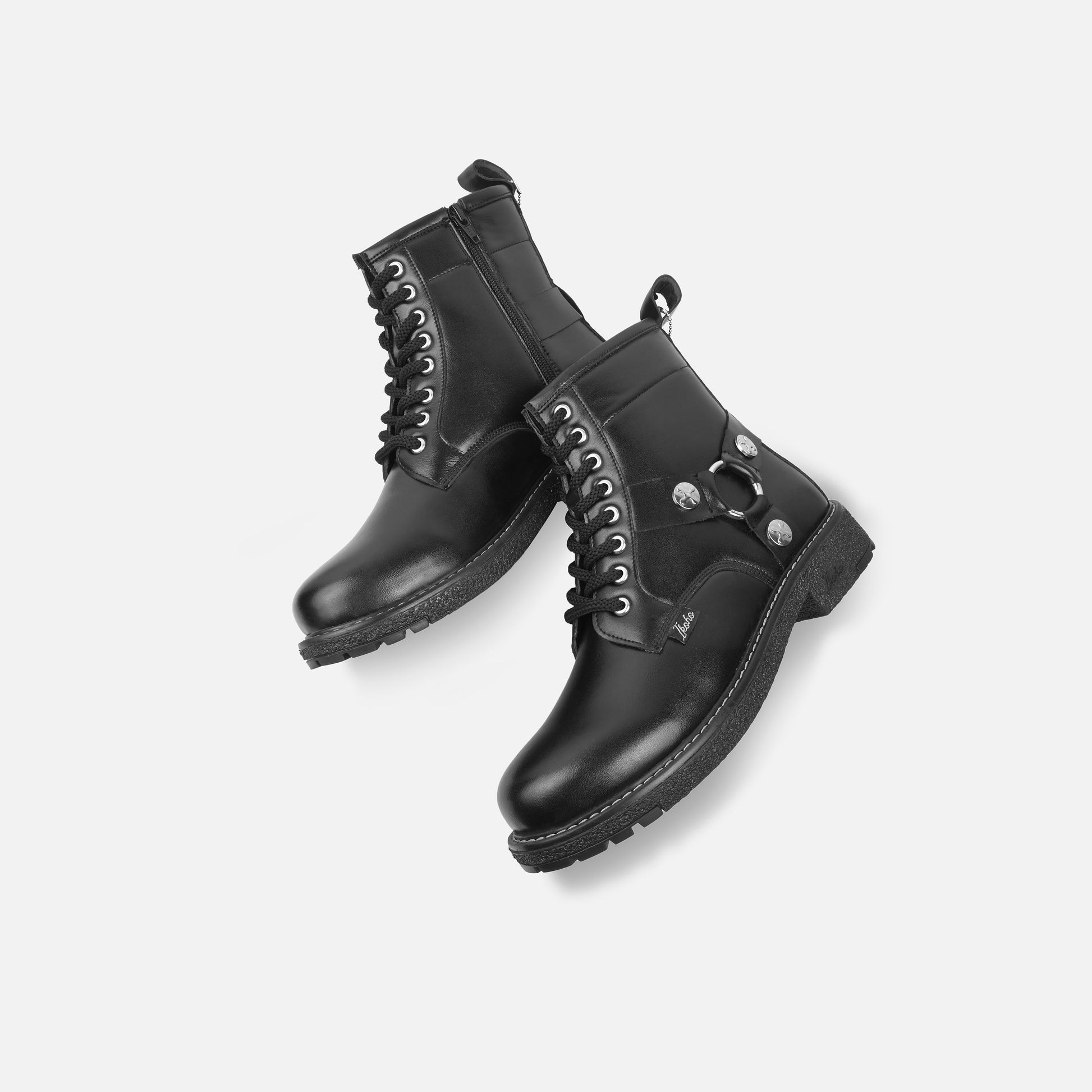 Pair of black leather boots on a light gray background